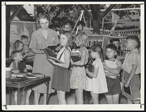A Moving Library. Children in line at Stearns Playground, Newton, receive summer reading from Mrs. Lucy Audolina of the Newton library. Left to right: Alfred Bertrand; Mrs. Audolina; Dolores Morrell; Lorraine Aucoin; Constance Bastinelli; Louis Salucci; and Robert Rasmussen.