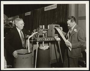 One of the hits of the American Textile Machinery Exhibition at Atlantic City, N.J., this week is the Pacific Evenness Tester, which Robert C. Wilkie, director of the Engineering Research Department of Pacific Mills at Lawrence, explained to hundreds of visitors at the show. With Mr. Wilkie is J. G. Anderson, (left), head of Anderson Machine Shop, Inc., the builder. The highly complex machine makes possible micrometer accuracy in measuring and recording variations in sliver and yarn uniformity in every known type of textile fibre.