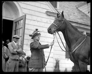 Unidentified man holding the reins of a horse