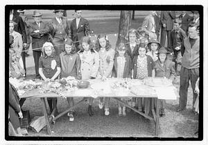 A group of girls behind a collection of flowers and baskets