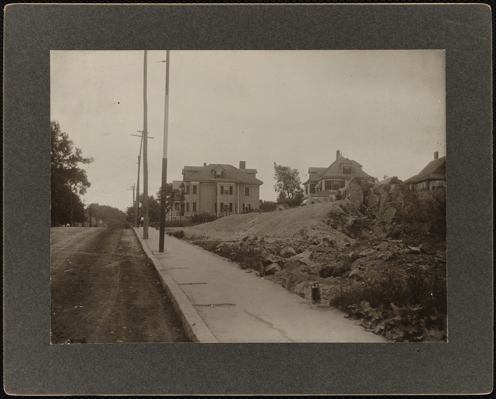 Residential street with some excavation work in the foreground and houses in the background