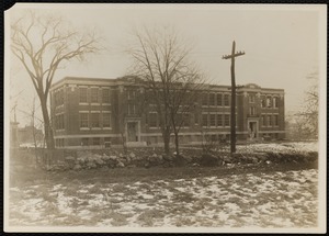 Building with rock wall and snow on ground