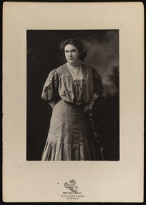 Unidentified woman standing next to a chair