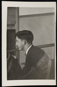 Young man, seated, from side