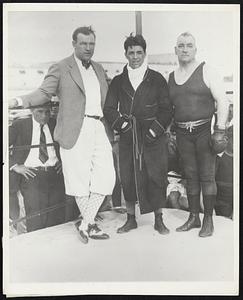Three Stages of Ringdom - Three stages of ringdom climbed inside the ropes together at the Miami Beach Kennel Club, Miami, Fla., recently. Here they are - Sammy Mandell in the center, flanked by Jack Sharkey, would-be heavyweight champ, and Tom Sharkey, once a contender for the heavyweight champ, and Tom Sharkey, once a contender for the heavyweight title. Jack is shown in the golf outfit he is 'most always seen wearing around the Miami Beach courses.
