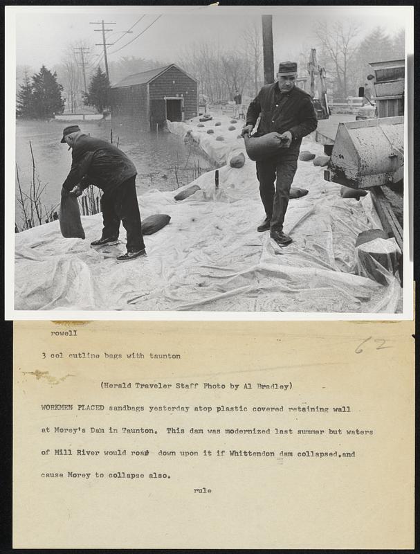 Workmen Placed sandbags yesterday atop plastic covered retaining wall at Morey’s Dam in Taunton. This dam was modernized last summer but water of Mill River would roar down upon it if Whittendon dam collapsed.and cause Morey to collapse also.