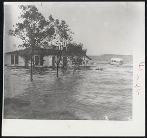 Hurricane Ione drove out this family in Belhaven, N. C., near the Pungo River. The flood waters from the big storm reached more than four feet. At right is half-submerged school bus. Heavy damage was reported in the Belhaven area.