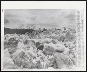 Ice Boulders--Massive piles of ice like this along the banks of the lower Niagara River are what Army Engineers hope to break loose today if weather permits blasting operations in the worst ice jam on the river in many years. Scraps of wreckage from a nearby boathouse can be seen near the top of the 40-foot-high mass.