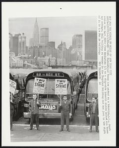 Strikebound buses are parked at a Brooklyn, N.Y., depot across the East River from Manhattan 1/1 as a city-wide transit strike halted all buses and subways. Tall building at center is the Chrysler Building and one just to the right of it is the Pan Am Building.