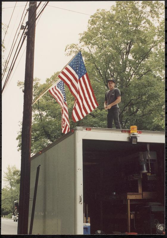 Seth Durno with flags, standing on truck