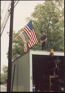 Seth Durno with flags, standing on truck