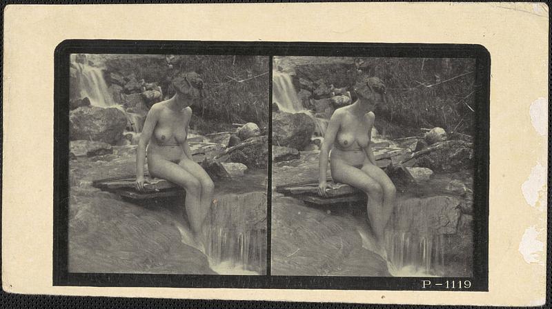 Naked woman outdoors, sitting on a ledge over a waterfall