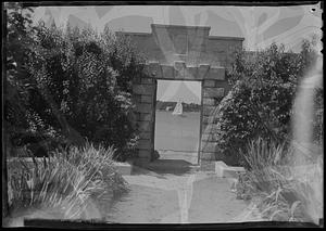 West gate of Mrs. A.C. Wilson's garden, #21 showing sailboat and windmill through gate