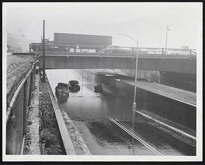 Stalled on Storrow Drive in the underpass beneath Massachusetts avenue, these cars blocked traffic. Underpasses throughout Greater Boston flooded as the rain came down faster than drains and catch basins could carry it away.