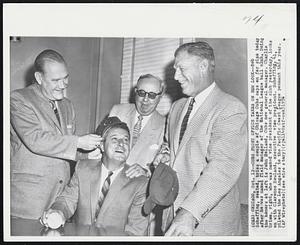 Chicago – Cubs Front Office Takes On New Look – Bob Scheffing, seated, tries a couple of Chicago Cubs caps on for size today after he was named field manager of the National League ball club. Doing the honors at left is John Holland, Cubs new general manager. Charlie Grimm, right, who was named vice president of the club yesterday, looks on with Clarence Rowland, executive vice president. Scheffing, 41, piloted the Los Angeles to the Pacific Coast League pennant this year.