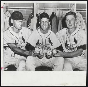 Big Hit – Stan Musial (center) is given help in putting four baseballs marked 2500 together by Cardinal teammates Wally Moon (left) and Red Schoendiest. Musial belted homer in sixth inning of game with Cincinnati to tie score and chalk up the 2500th hit of his major league career.