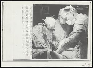 Implant Mechanical Heart--Dr. Denton A. Cooley, right, with Dr. Domingo Liotta, left, as they implant the mechanical heart into the chest of Haskell Karp, 47, of Skokie, Ill. The operation was performed at Houston's St. Luke's Episcopal Hospital. The mechanical heart implantation was done to keep Karp alive until a suitable heart transplant donor can be found. In the background is Dr. Grady Hallman.