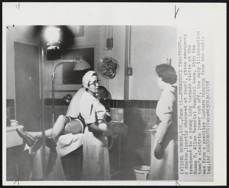 Emergency Treatment--A doctor, (partly obscured at rear), gives emergency treatment to a young lady tornado victim at the Susan B. Allen Memorial Hospital here. With the town's electric power cut off, the only illumination was from a gasoline lantern hanging from the ceiling.