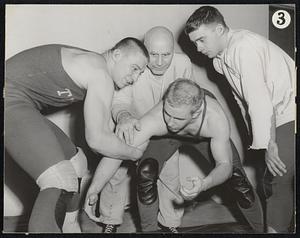 No penalties for holding in wrestling, as coach Sam Ruggeiry explains to grappling Ray Fisher (left) and Bill Baskin as John Williams watches.