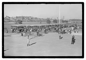 A crowd of people gathered by buses