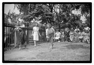 Two young women playing horseshoes