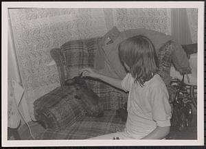 Young person with a rabbit on a sofa chair