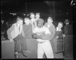Jackie Robinson of the Brooklyn Dodgers signs autographs for kids at Braves Field