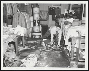 Cleaning up Haberdashery Damage in Alpers Men's Store Peabody square, in Saul Bass. hats and other clothing were floating in two feet of water, and racks of suits were damaged.