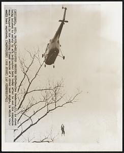 Xenia, Ohio. -- Helicopter Rescues Boy -- Charles Henderson, 17, is shown being hoisted to safety by afb helicopter here today after he and his companion were trapped in the swirling flood waters of a river last night, in which their small boat capsized.