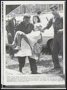 A Lift to Safety--A Coast Guardsman carries an elderly woman aboard a helicopter to be airlifted from a hospital in the Bay St. Louis, Miss. area which was hard hit by Hurricane Camille. The storm left the hospital without electricity or water and patients were flown to New Orleans.