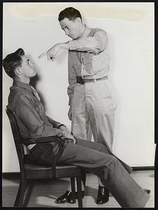 PVT. Lee Burchell of Lowry Field, Colo., a professional magician and hypnotist in civilian life, hypnotizes Pvt. George Bent Jr., also of Lowry Field. Bent sits relaxed in the chair and concentrates on Burchell’s finger as it circles in front of him, listening meanwhile to the command “Sleep” voiced by Burchell.