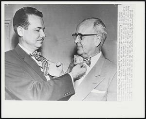 Only $10,000??--Warren Robinson, a diamond salesman, takes a look at the "simple" bow tie--made out of a $10,000 bill--worn by Philip Reid, a bank president, at the Dallas Civitan Club's annual "necktie contest". Robinson, who had the flashiest tie at the contest, wears a black string bow tie adorned with $45,000 worth of diamonds, star sapphire and platinum bracelets and rings. One rings was a 5-carat diamond. Neither man won the prize.