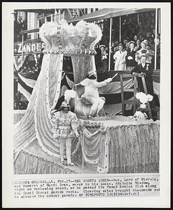 Rex Greets Queen--Rex, Lord of Misrule, and Monarch of Mardi Gras, waves to his queen, Adelaide Wisdom, right on reviewing stand, as he passed the famed Boston Club along the Canal Street parade route. Clearing skies brought thousands out to witness the annual parade.