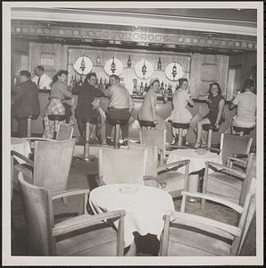 Interior view of a restaurant, with women seated at bar