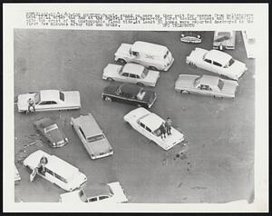 People stand on cars as they wait for rescue from helicopters here 12/14 after the dam at the Baldwin Hills Reservoir burst tossing houses and automobiles onto the crest of an unstoppable flood tide. At least 50 homes were reported destroyed in the first few minutes after the dam broke.