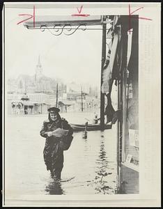 A letter carrier does his daily rounds through flooded streets in Weymouth Landing 3/18 as a northeast storm deposited almost five inches of rain in Boston and parts of New England