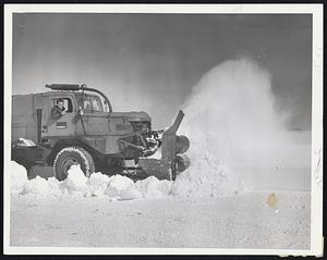 The Real Cold War - A big snowfighter hurls into the drifts at the East Boston airport, always one of the hardest-hit storm fronts because of the sweep of drifts across the open runways.
