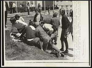 A Kent State University stude[nt] lies on the ground after National Guardsmen fired into a crowd of demonstrators here today. Four persons were reported dead and 11 wounded