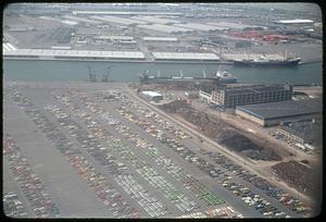 Aerial view of docked ships, parked cars in foreground