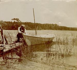 Man pulling boat by dock, Long Pond, South Yarmouth, Mass.