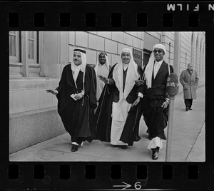 Group of men wearing bisht over thawb outside Sheraton Plaza Hotel