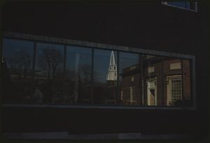 Window of Lamont Library, with reflections of church steeple and other buildings, Cambridge, Massachusetts