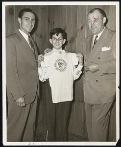 A champ of tomorrow, John Connolly of South Boston, get a pat on the back from Sibby Sisti, Braves shortstop, and Jack Sharkey, former world's heavyweight boxing champ, as he displays the jersey he received at the first annual Award Night Dinner at the South Boston branch of the Boys Clubs of Boston. 104 boys received awards for excellence in all Branches of athletics. Messrs. Sisti and Sharkey were head table guests. Sisti is a member of the Buffalo Boys Clubs.