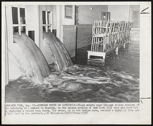 Running Water in Cafeteria--Flood waters pour through broken windows of the cafeteria of a school in Bayside, in the Queens section of New York City that was hard hit by yesterday’s record rain storm. The water, up to the tables here, reached a depth of five and a half feet in the cafeteria.