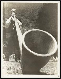 It's a Horn- Looks like a pipe, but it's an Alpine horn. A good "blower" can make it heard for miles. This picture was taken during a horn-blowing contest in Switzerland recently.