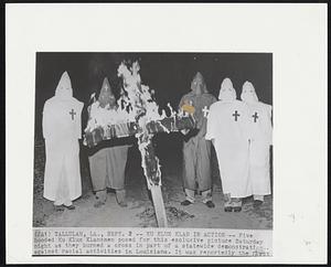Ku Klux Klan In Action-- Five hooded Ku Klux Klansmen posed for this exclusive picture Saturday night as they burned a cross in part of a statewide demonstration against racial activities in Louisiana. It was reportedly the first.