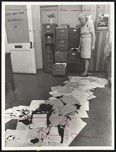 Paint-Spattered draft records strewn on floor of Local Board No. 31, Selective Service system, are looked at by Miss Ann Hernon, executive secretary.