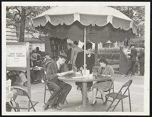 Like a Beach Under New York's new outdoor amusements comes the outdoor library which opened May 18 at Bryant park, right by the public library on Fifth avenue. Portable bookshelves furnish ready material for readers. Patrons are plentiful on bright days, and many workers grab a book and a lunch together. These booklovers were taking advantage of the sunshade.