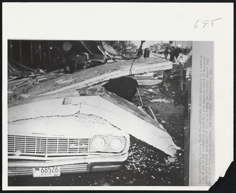 Earthquake Crushes Car--This is a close-up view of one of the automobiles parked on a main downtown street of Anchorage which were crushed when walls of the J.C. Penney Co. building sheared away in a major earthquake yesterday.