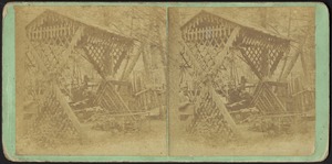 Men seated below garden trellis
